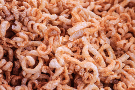 Close-up view of pork snack, pork rind, pork scratching, pork crackling. That is pork rind, leather or leather lean pork fried crispy and blistered. Junk Food that's Good for You.の写真素材