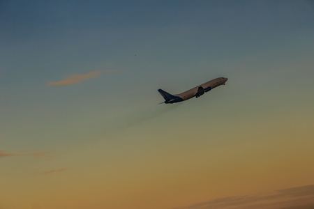 Airplane taking off from the runway airport, uprising with clouds in the blue sky backgroundの写真素材