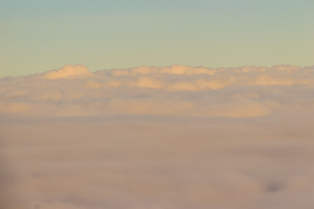 Beautiful cloudscape from sky aerial view. Beauty of nature view from above the sky and clouds. White clouds and blue sky view from airplane window. Sunlight in the sky shines on clouds.の写真素材