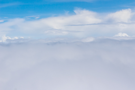 Beautiful cloudscape from sky aerial view. Beauty of nature view from above the sky and clouds. White clouds and blue sky view from airplane window. Sunlight in the sky shines on clouds.の写真素材