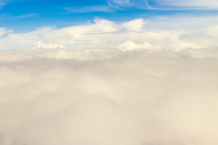 Beautiful cloudscape from sky aerial view. Beauty of nature view from above the sky and clouds. White clouds and blue sky view from airplane window. Sunlight in the sky shines on clouds.の写真素材