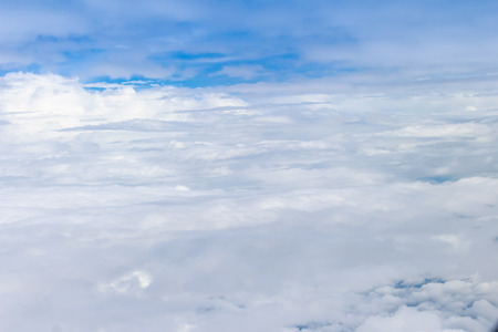 Beautiful cloudscape from sky aerial view. Beauty of nature view from above the sky and clouds. White clouds and blue sky view from airplane window. Sunlight in the sky shines on clouds.の写真素材