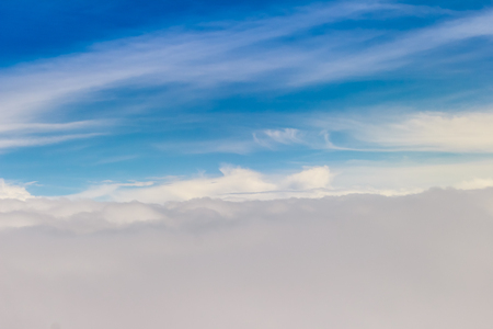 Beautiful cloudscape from sky aerial view. Beauty of nature view from above the sky and clouds. White clouds and blue sky view from airplane window. Sunlight in the sky shines on clouds.の写真素材