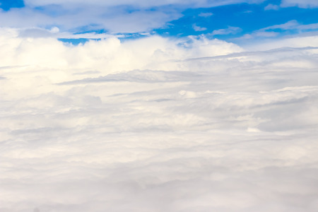 Beautiful cloudscape from sky aerial view. Beauty of nature view from above the sky and clouds. White clouds and blue sky view from airplane window. Sunlight in the sky shines on clouds.の写真素材