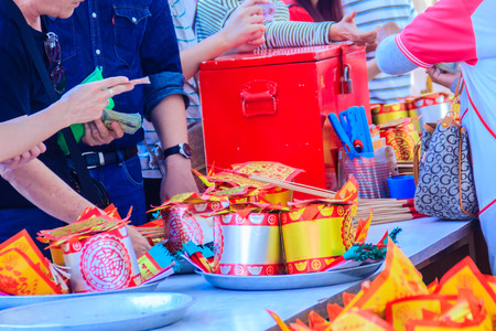 People buying paper money ,paper gold and joss stick sets at Chinese shrine for making merit and pay respect to god in Chinese New Year day may life be blessed with health and happiness all through.の写真素材