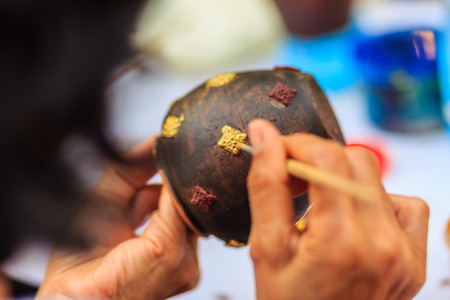 Close up hand of sculptor during painting the masterpiece of porcelain jar patterns,の写真素材