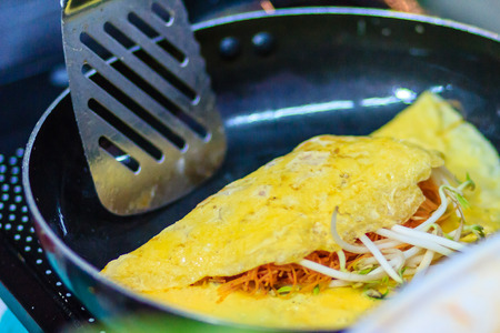 Close up hand of vendor during cooking for the original Thai Fried Noodle(Pad Mee Boran), stir-fried noodle with shrimp and egg commonly served as a street food popular in Thailandの写真素材