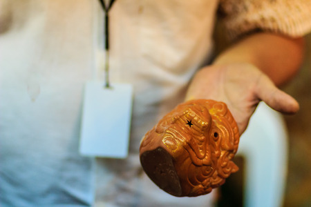 Close up hand of Thai sculptor during painting the masterpiece of hanuman puppet doll at night marketの写真素材