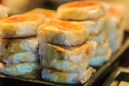 Moon cake or Chinese ancient dessert called 'Pia',ancient dessert Made from flour to Baking heat Mashed golden beans stuffed with salted egg yolk,Chinese pastry or moon cake.の写真素材