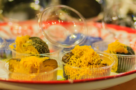 Custard in pumpkin, pumpkin custard with sweet egg floss topping, Thai dessert at night market in Bangkok, Thailand.の写真素材