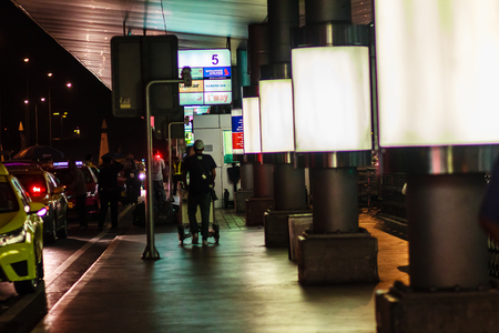 Bangkok,Thailand - February 21, 2017: Unidentified passengers carrying his luggage and hailing for taxi on late night at the front of Suvarnabhumi International Airport, Thailand.のeditorial素材
