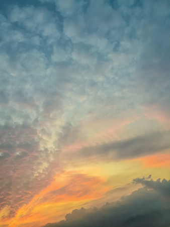Red clouds on blue sky in twilight evening. Beautiful sunset sky with blue and red background. Dramatic colorful of dusk and dawn sky with blue sky and red clouds.の写真素材