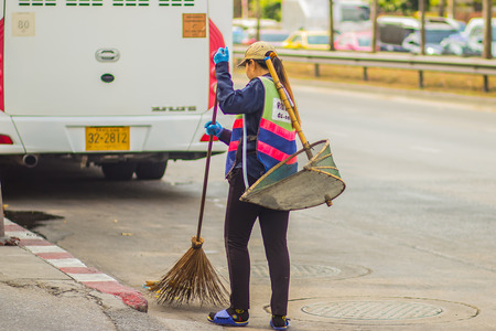 Bangkok, Thailand - February 21, 2017: View of Bangkok municipal staff sweeping the garbage on the street. Road sweeper worker cleaning city street with broom toolのeditorial素材