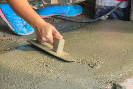 Mason worker use trowel to smooth or leveling liquid concrete of flooring work in step of the building improvement.の写真素材