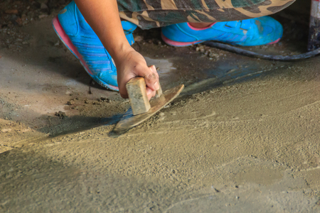 Mason worker use trowel to smooth or leveling liquid concrete of flooring work in step of the building improvement.の写真素材