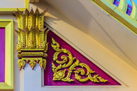 Beautiful Thai's style craving and decoration in golden column and gable of the Buddhist temple.の写真素材