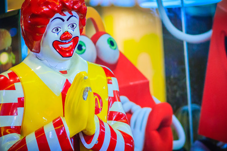 Bangkok, Thailand - March 2, 2017:  Mc Donald's doll in Thai culture greeting customer in front of the shop. McDonalds shop at the entrance with brand's logo and welcome doll.のeditorial素材