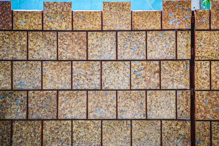 Brown ceramic tiles patterned in dirty laterite stone wall texture background.の写真素材