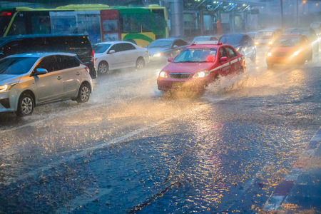 Bangkok, Thailand - July 6. 2017: Driving car through the heavy rain in the evening. Traffic under heavy rain with hail in dangerous situation with low visibility, slippery and splashing water.のeditorial素材