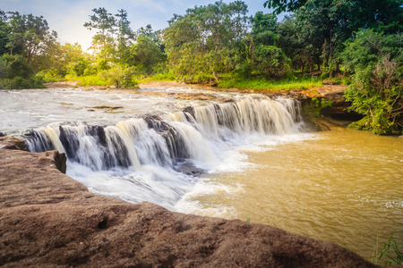 Exotic small waterfall for swimming named "Tadton Waterfall" in Ubon Ratchathani, Thailand. This cascade falls from a rocky bend like a movie screen through the large rock with large water flow.の写真素材