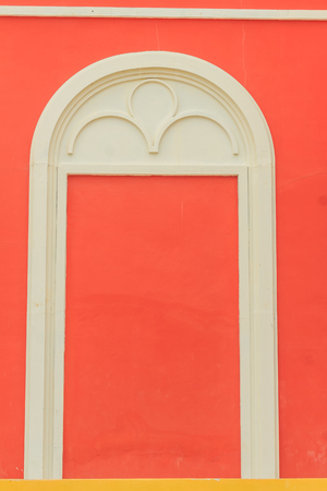 Classic white arch door pattern on the red wall background.の写真素材