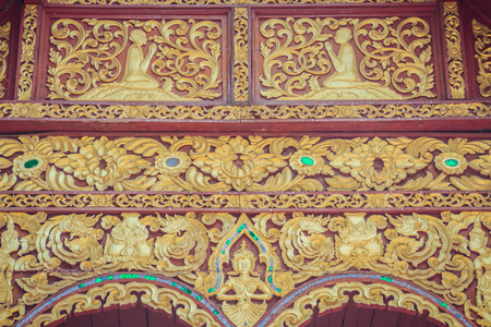 Beautiful craved Buddha with animals in forest patterns on the gables of the Thai's northern style church at Wat Chedi Liam, one of the ancient temple in Wiang Kum Kam archaeological area, Chiang Mai.の写真素材