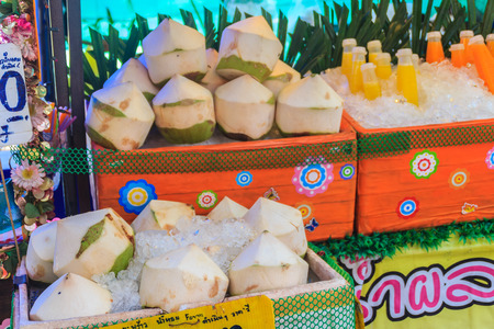 Chiang Mai, Thailand - May 3, 2017: Peeled young coconuts on ice box were displayed for sale as coconut juice at street food stall with price tag.のeditorial素材
