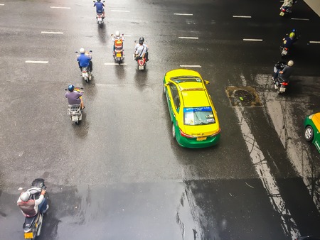 Bangkok, Thailand -October 14, 2017: Motorbikes and cars are speed up when the green traffic sign appeared at the four junctions at Saladaeng nearby Silom and Lumpini park, Bangkok, Thailand.のeditorial素材