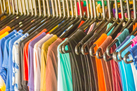 Row of summer sale clothes hanging on the rack. Fashion clothes on Sales at the flea market.の写真素材