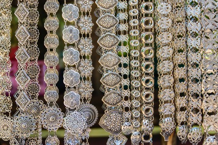 Beautiful vintage silver belts pattern detailed in thai style fashion for women in the antique market. Shop for souvenir handcraft belt as vintage fashion at the local market in Chiang Rai, Thailand.の写真素材