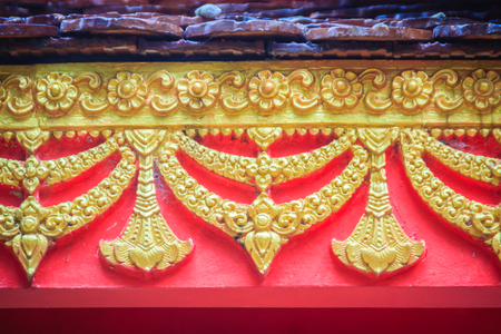 Beautiful traditional golden Thai style stucco patterned for decorative on wall background at...