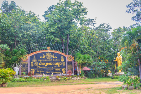 Ubon Ratchathani, Thailand - August 27, 2017: Golden entrance gate signboard with nae plate of Wat Phu Phlan Sung or Phuu Phalarn Soung temple at Nachaluay District, Ubon Ratchathani, Thailand.のeditorial素材