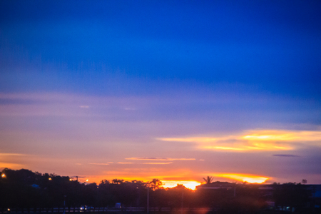 Dusk sky and cloud at morning dawn background. Vibrant colors of the sky with clouds from dusk till dawn. Dramatic evening cloudscape in the city. Twilight sky began to change from blue to orange.の写真素材