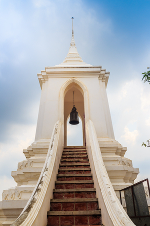 Beautiful white buddhist belfry on the hilltop with blue sky background at Wat Phraputthachai temple, Saraburi, Thailand. This temple is public for entry and tourist can enjoy the 360-degree view.の写真素材