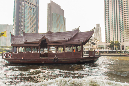 Traditional wooden boat with restaurant on the Chao Phraya river cruising tour. River view of the tourist boat takes visitors for sightseeing tour in Bangkok along the Chao Phraya River.の写真素材