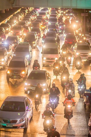 Bangkok, Thailand - December 20, 2017: Heavy traffic jams in Bangkok city with row of cars and motorcycles on the road at night after work. Traffic jam in night time at Sathorn Intersection, Bangkok.のeditorial素材