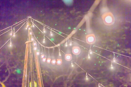 Blurred light with bokeh background of temple fair in Thailand. Walking street market with blurred people and bokeh light. Abstract blurred circular bokeh background.の写真素材