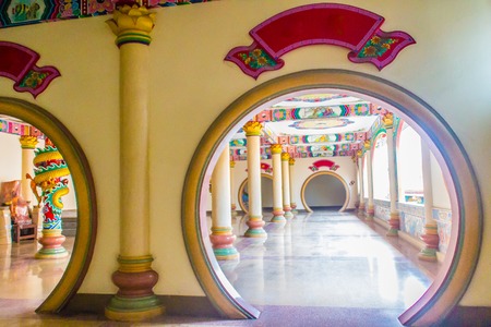 Chinese traditional circle shape door, moon gate, or round doorway in the public Chinese temple. Chinese architecture gate with chinese style painting in background.のeditorial素材