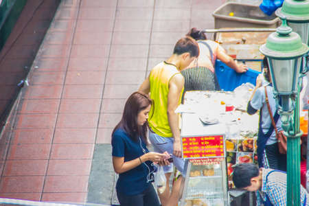 Bangkok, Thailand - September 05,2018: Thai female street vender is selling food to the customerのeditorial素材
