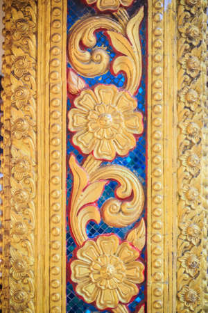 Golden flowers carved on the column at the Buddhist templeの写真素材