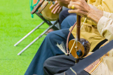 Closeup the musician during play the Sailor (Lanna Traditional Fiddle), a Thai musical instrument such as stringed instruments. Make a sound by using the bow rub to the strung.の写真素材