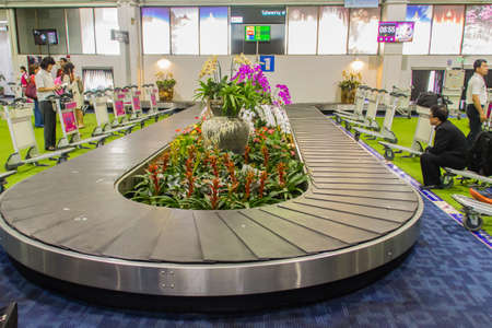 Chiang Rai, Thailand - June 13, 2017: Baggage conveyer with beautiful orchid decoration at Mae Fah Luang - Chiang Rai International Airport, Chiang Rai, Thailand.のeditorial素材