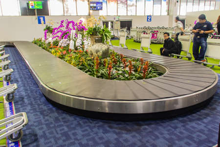 Chiang Rai, Thailand - June 13, 2017: Baggage conveyer with beautiful orchid decoration at Mae Fah Luang - Chiang Rai International Airport, Chiang Rai, Thailand.のeditorial素材
