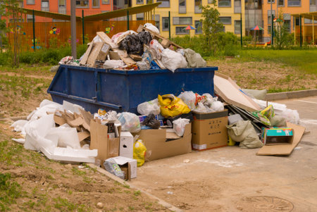 Crowded dumpster in the area of construction of a new urban residential area.