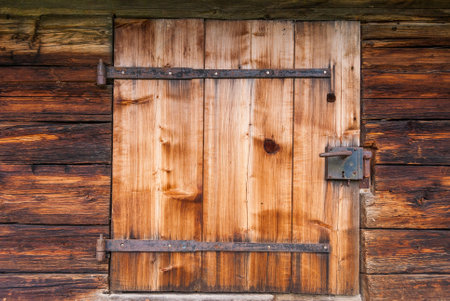 Old wooden door with lock and wrought-iron hinges.の写真素材