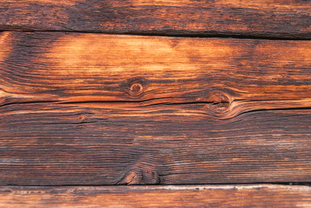 horizontal wooden planks of an old Swiss mountain hut darkened by the sun and winter weather of the Alps, Switzerland.の写真素材