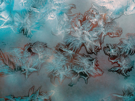 beautiful Christmas frosty pattern with white snowflakes on blue background on window.の写真素材