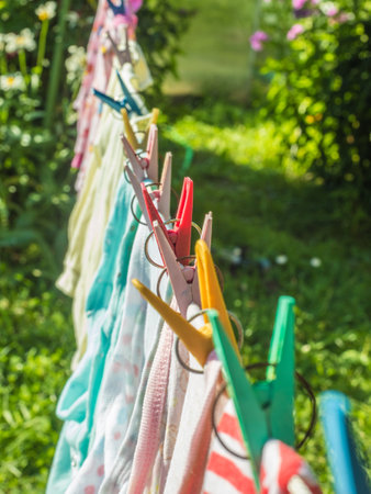 Row of clothespins and children's underwear on a ropeの写真素材