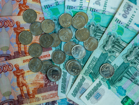 Scattered ruble banknotes and coins close up