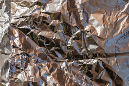 Silver background of crumpled metal foil, decorative texture, bright shiny natural texture of...